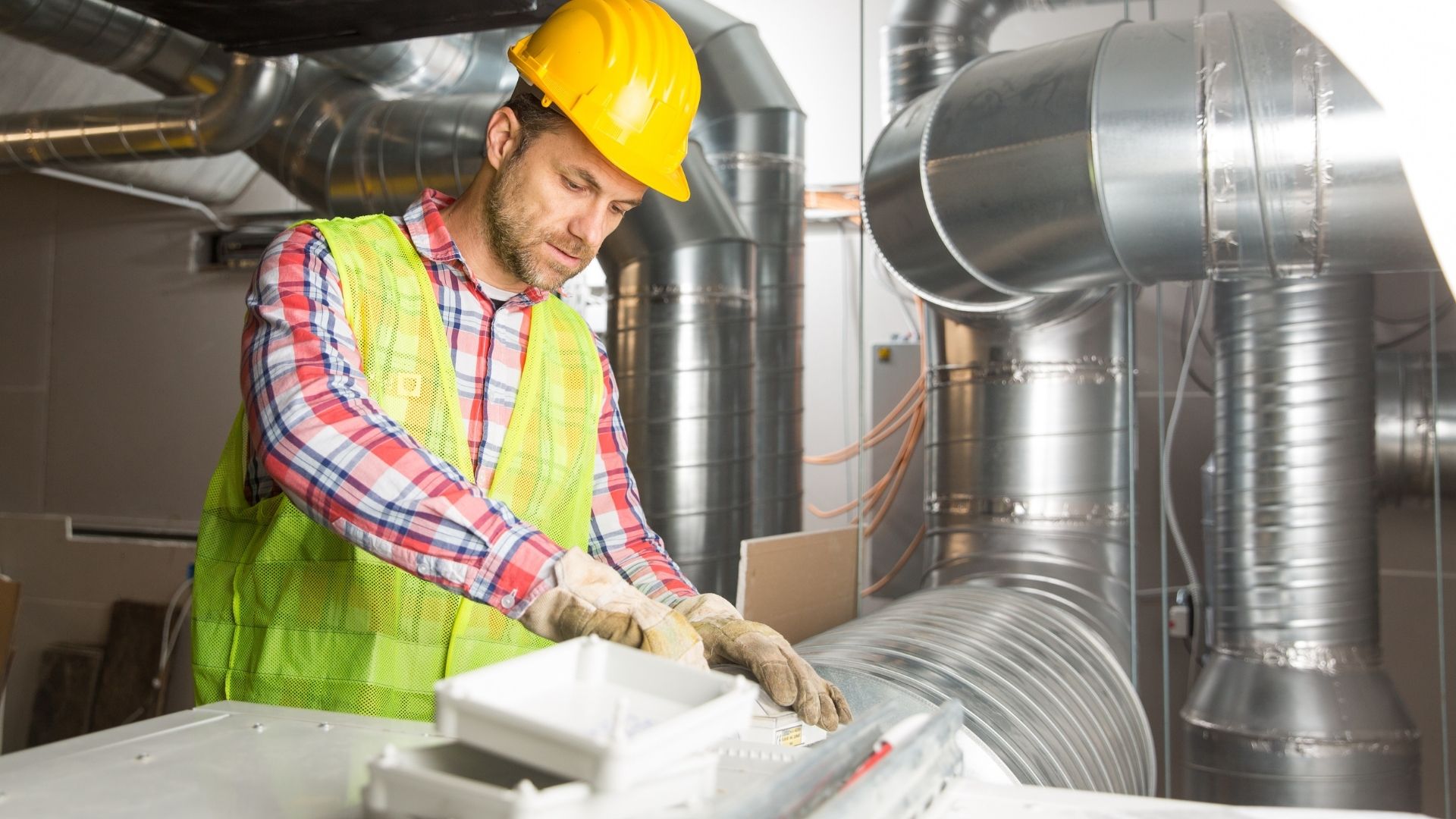 A mechanical contractor working on air vents.