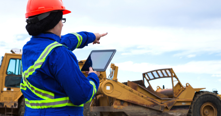 A construction worker managing her workforce in the field from the cloud.