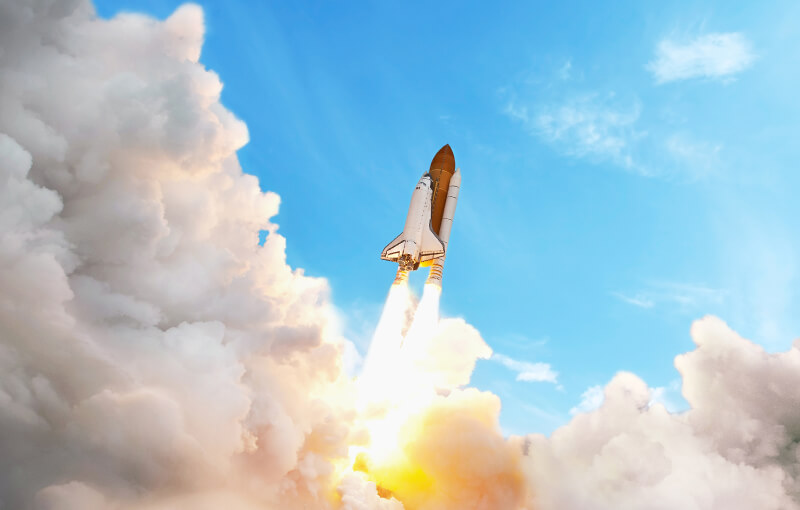 Rocket launching into a clear blue sky