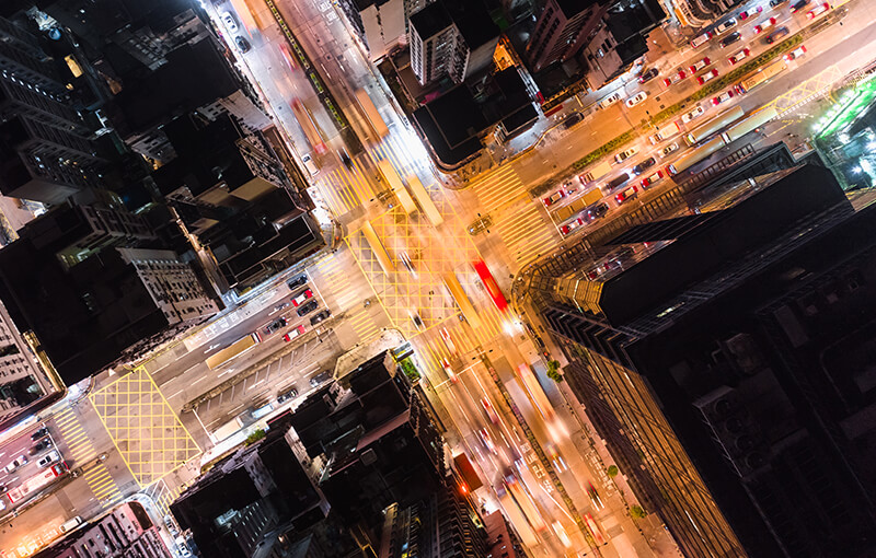 Birds-eye view of an city road intersection at night.
