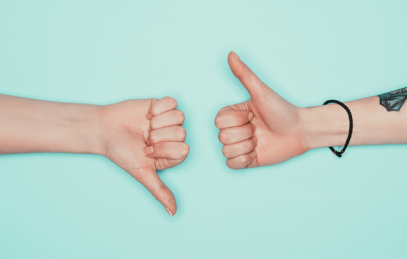 Two hands on a blue background, one gives the "thumbs up" and the other "thumbs down" - Neovation Learning Solutions