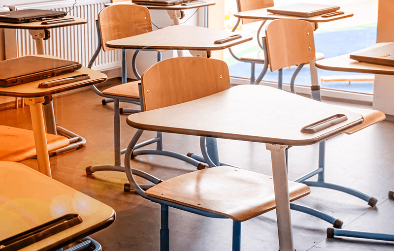 Series of modern wooden desks in an empty classroom - Neovation Learning Solutions