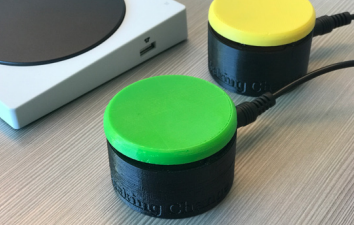 Two accessible swtiches: Short, cylindrical buttons, one with a green top, one with a yellow top.