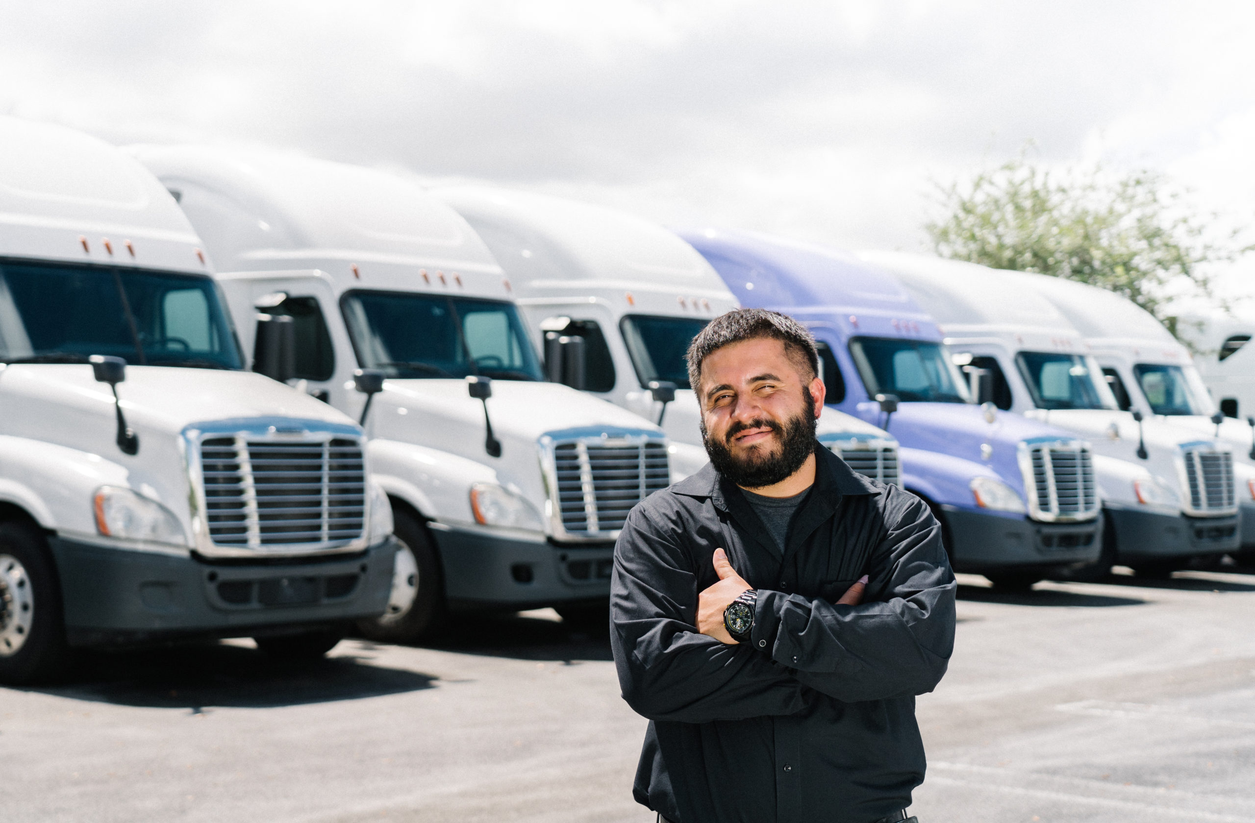 A Fleet Owner Stands in Front of Tractor Vehicles He has Listed on COOP