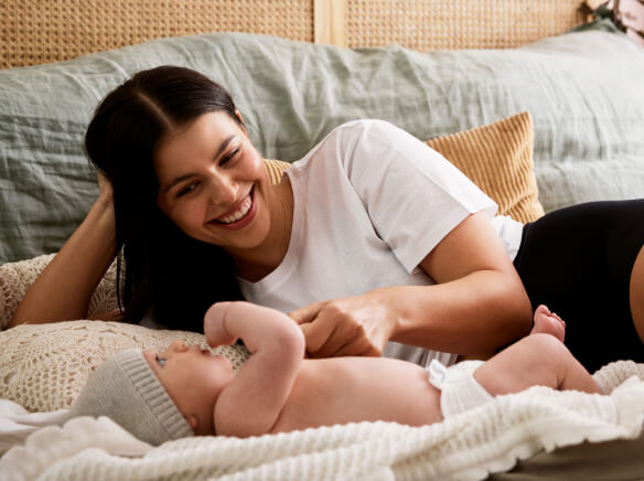 a woman laying with a baby