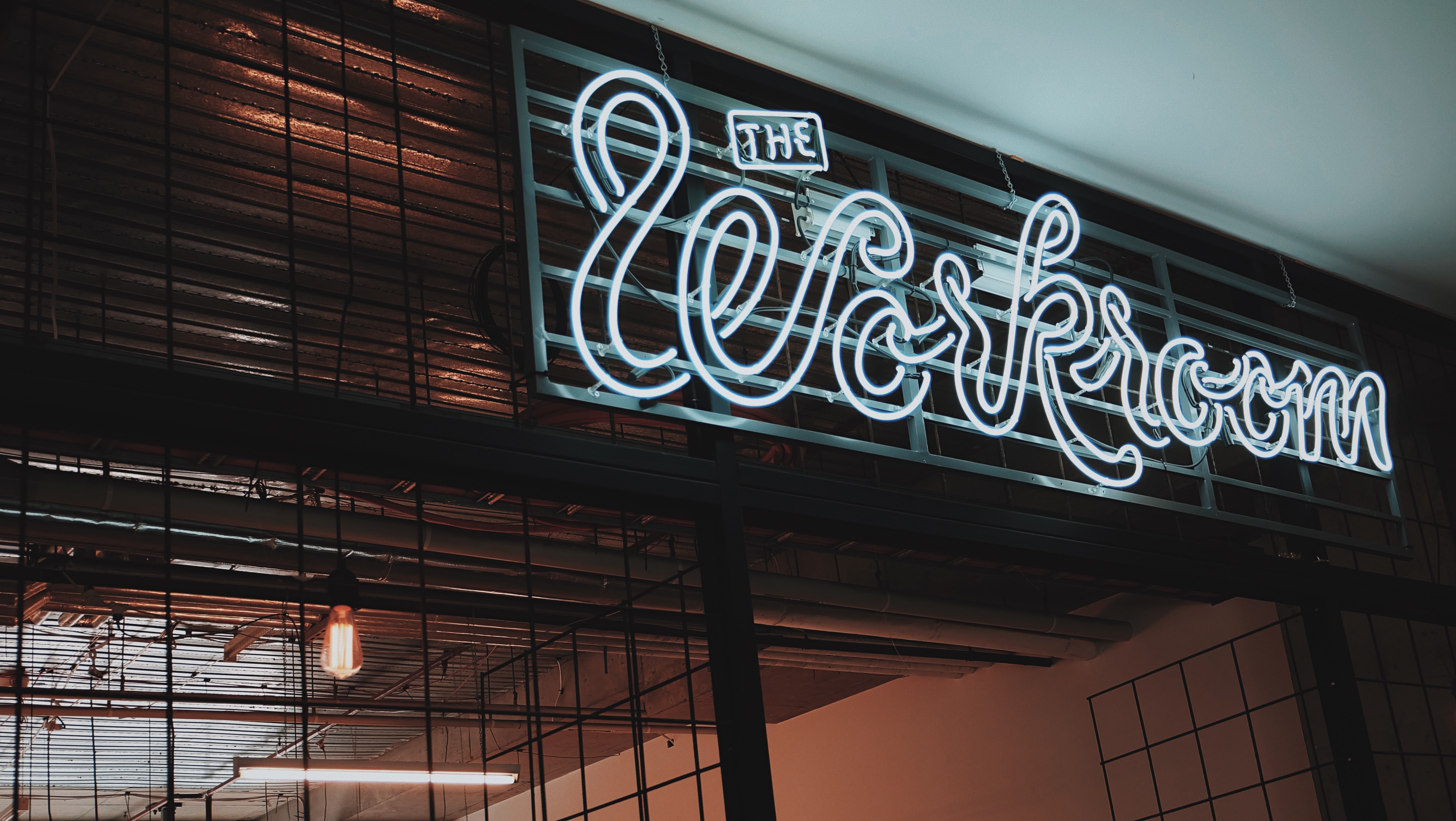 Image of blue neon sign with the text "The Workroom"
