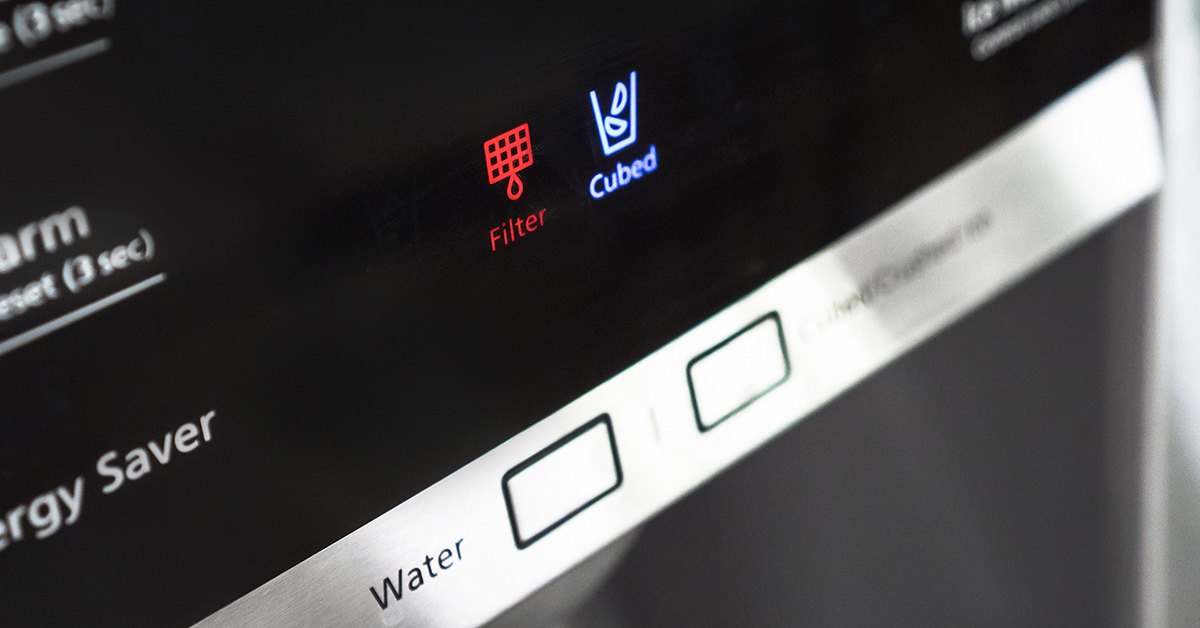 How do I reset the water filter indicator light on my refrigerator?