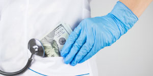 Hand with medical glove putting money in pocket