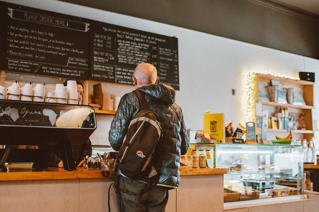 man standing at counter in cafe