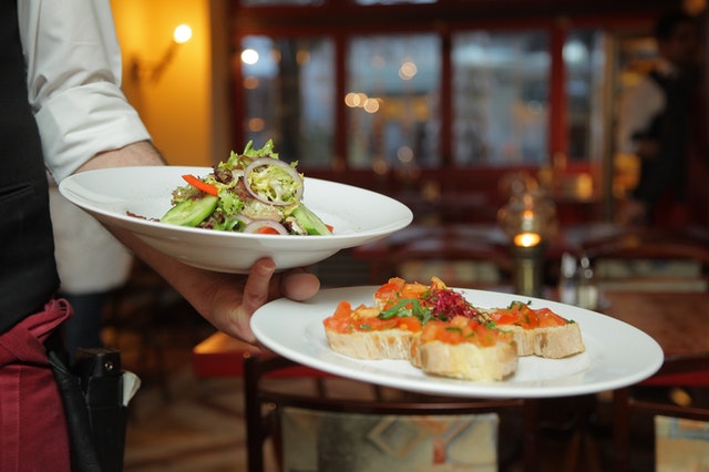 hand holding two plates of food