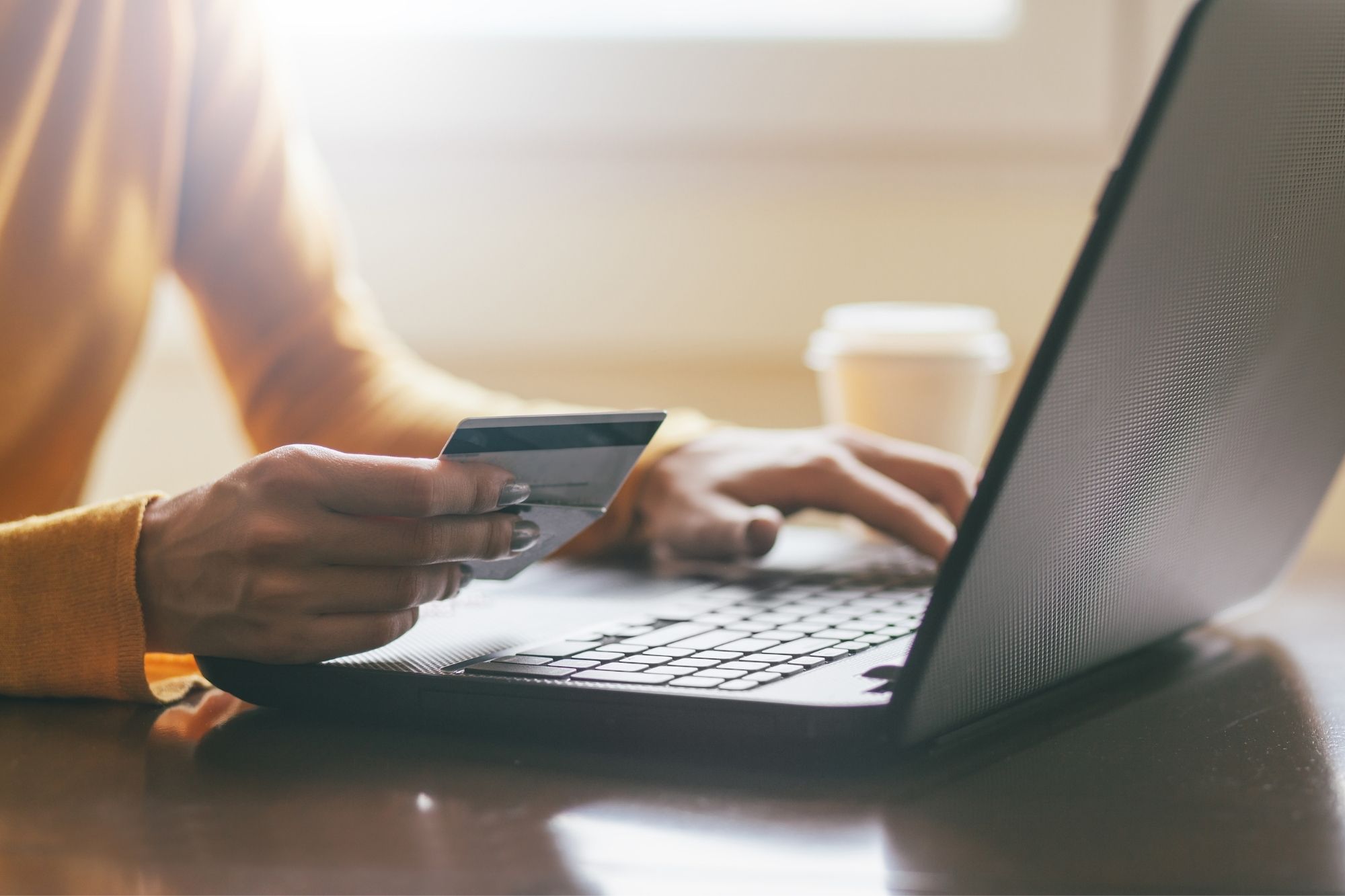 woman holding credit card at computer