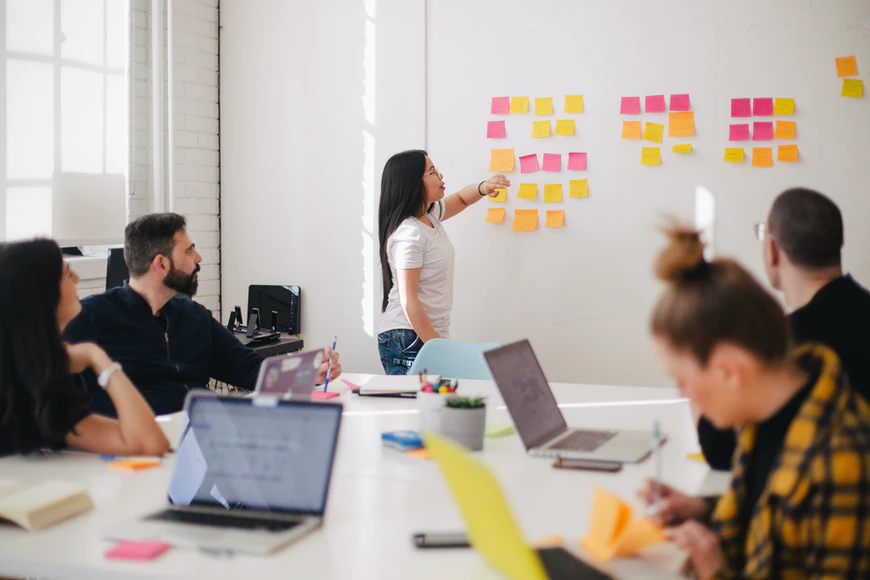 team of employees brainstorming at whiteboard