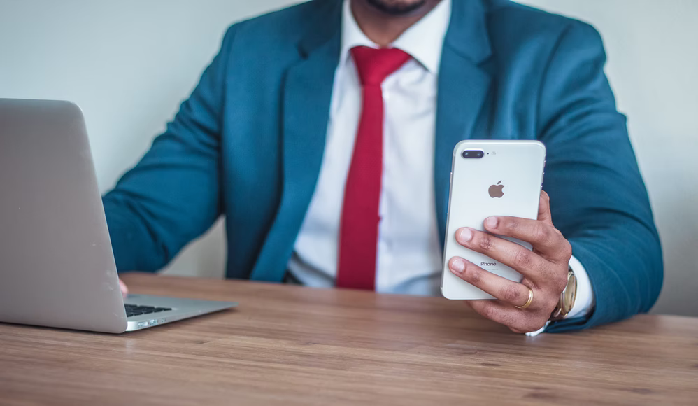 man sitting at desk using phone