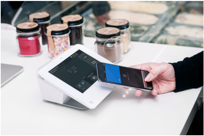 woman paying with phone using Clover POS