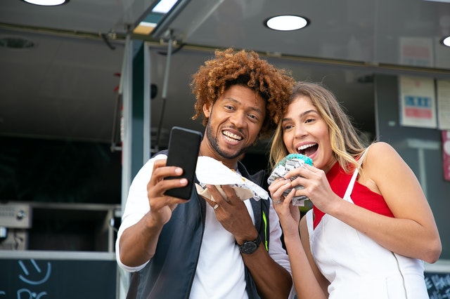 two people eating outside food truck