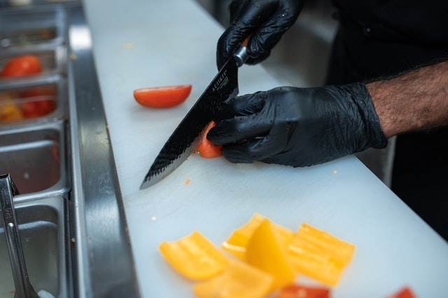 person holding knife dropping vegetables