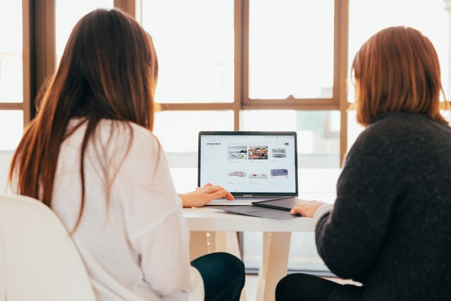 two coworkers sitting at laptop