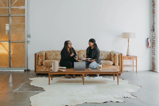 man and woman sitting on couch talking