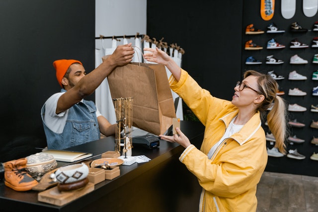 A cashier handing a customer their purchase