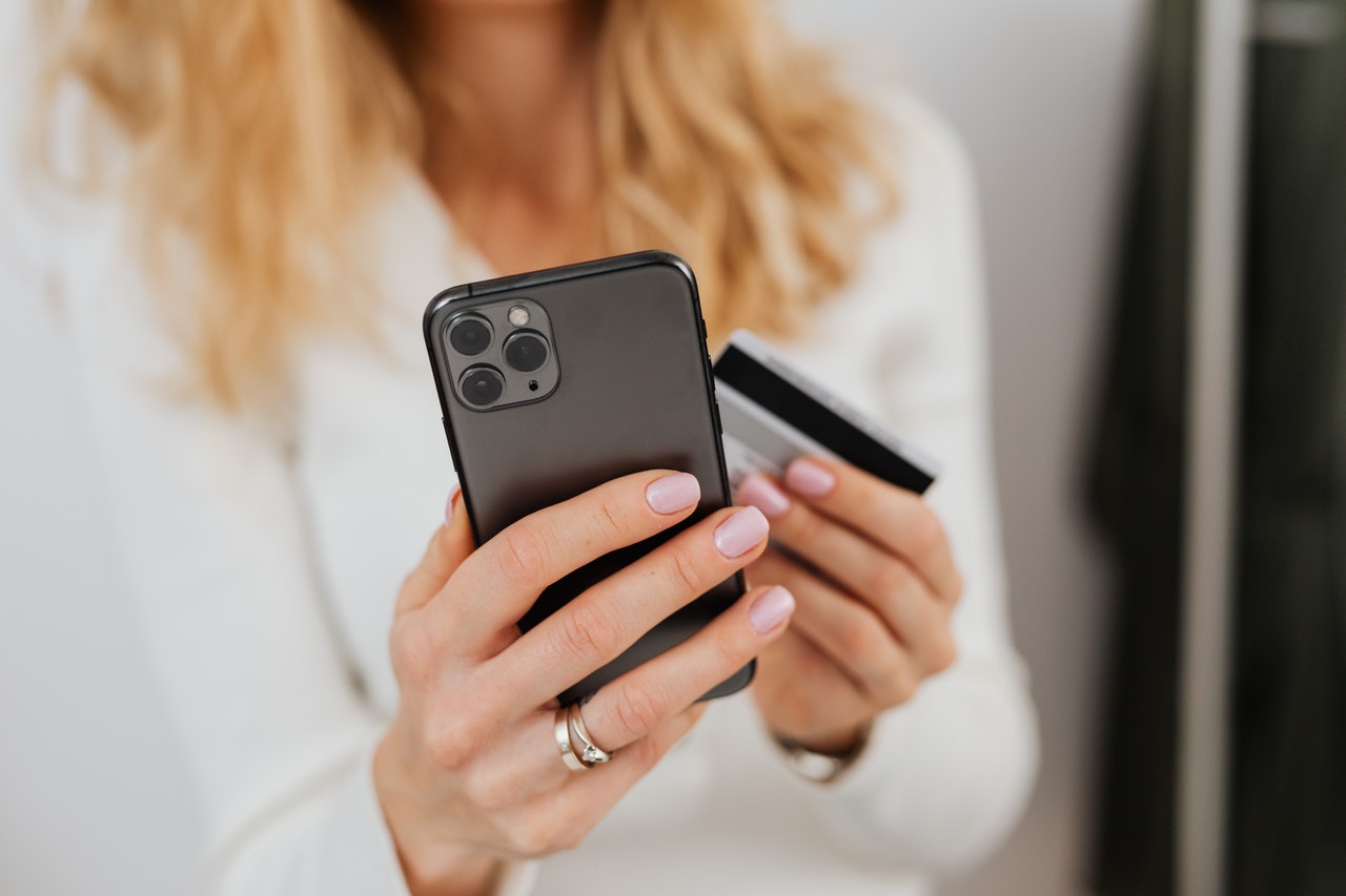 woman shopping on phone holding credit card