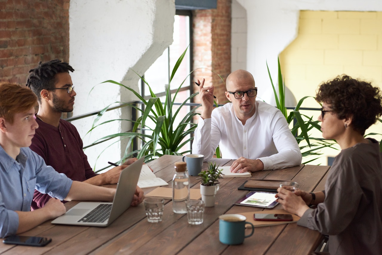 A business meeting between four coworkers at a table