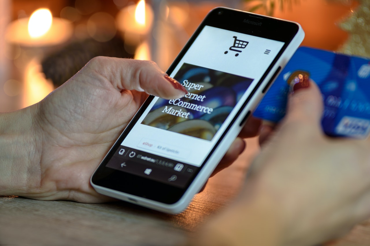 A customer shopping on their phone while holding a credit card