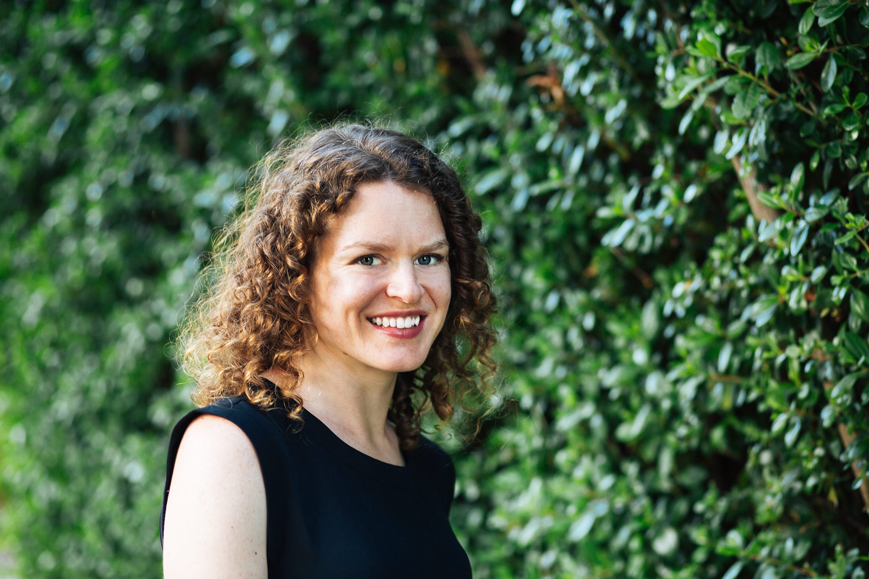 Tara (woman) in front of greenery