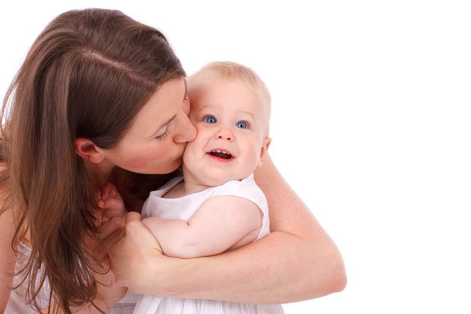 A mom kissing her child on the cheek.