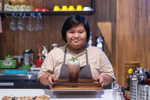 Disabled woman serves drinks at her job