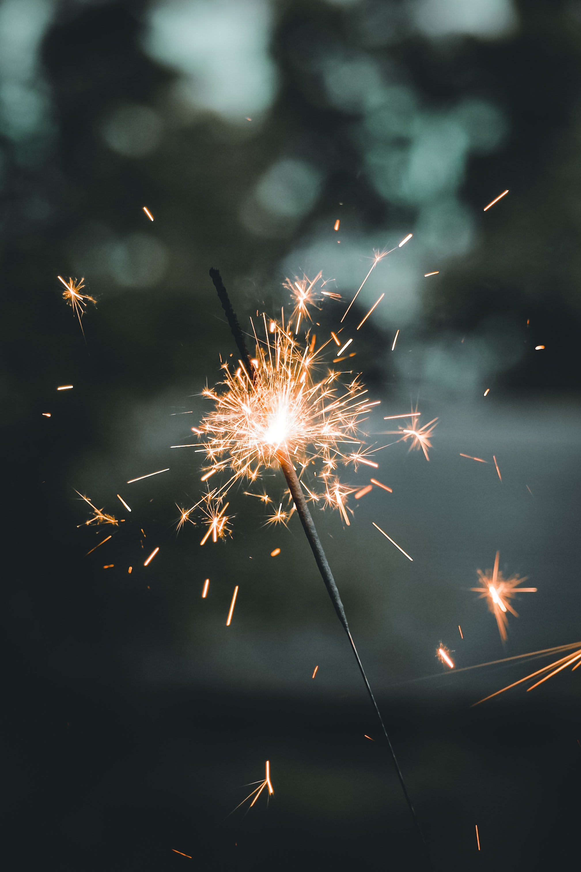 A lit sparkler in the evening