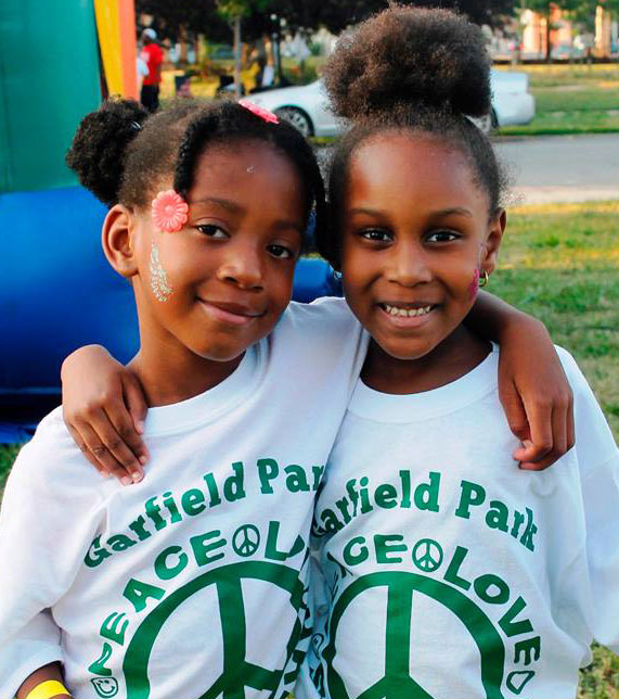 Two young girls smiling in front of bouncy house