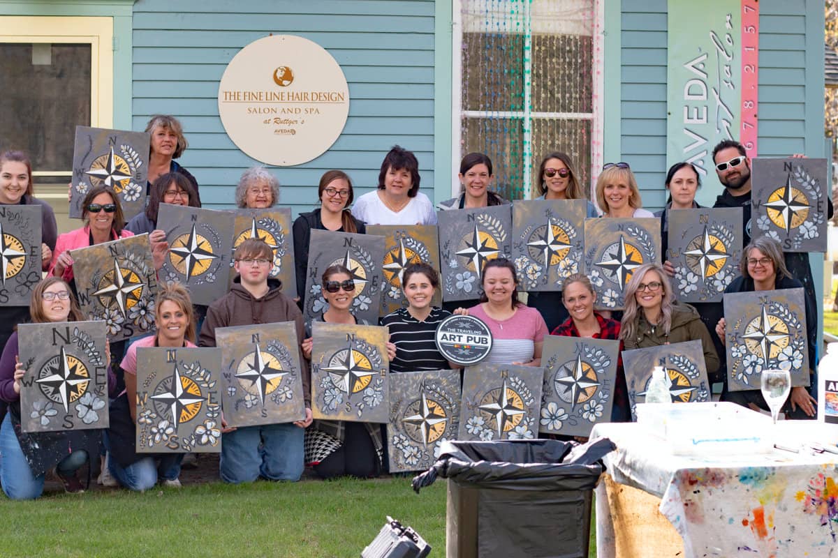 Team building group outside holding artwork