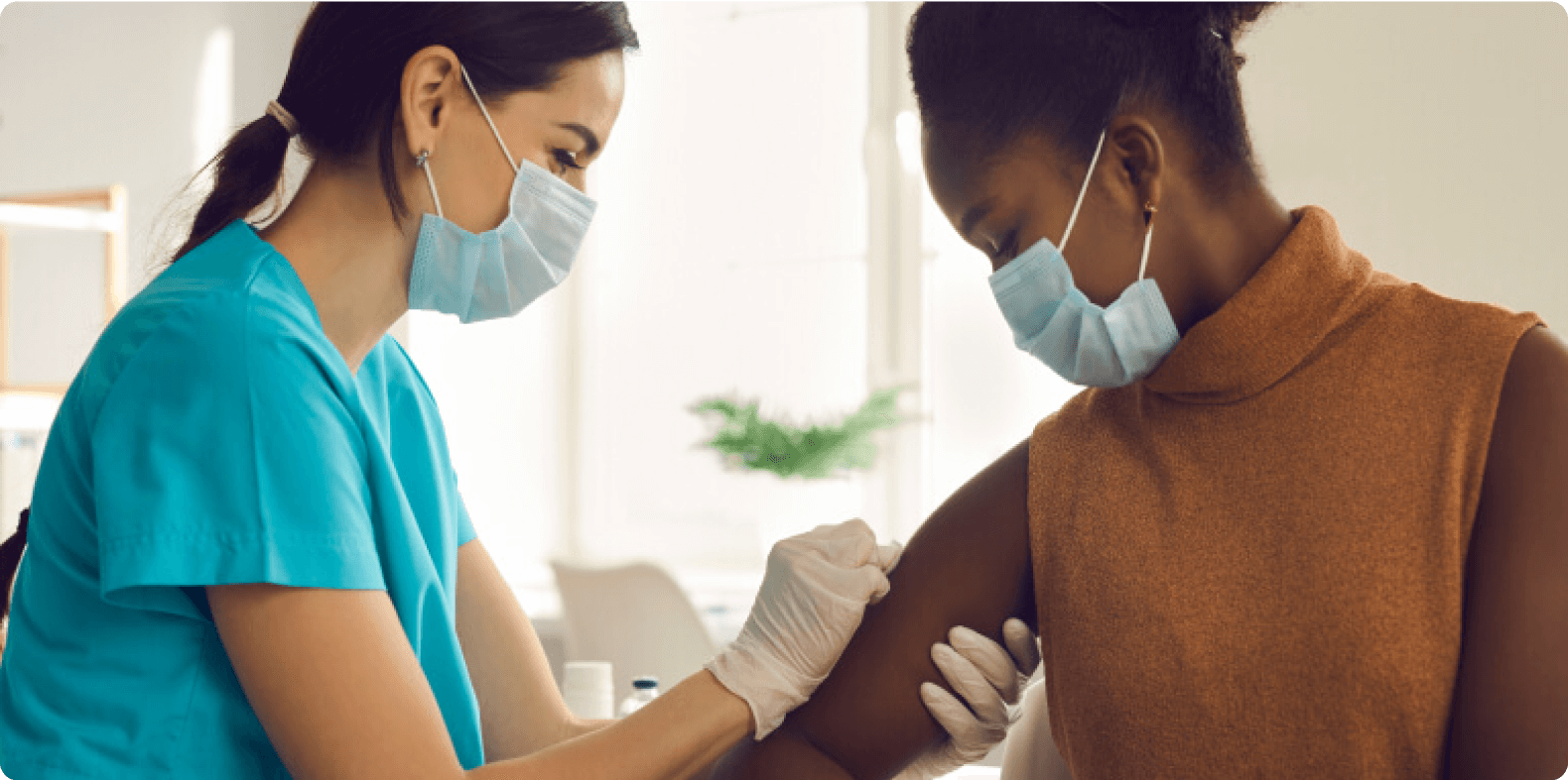 masked nurse giving vaccination to woman