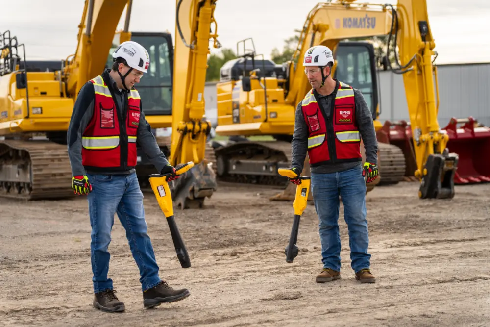 Two GPRS Project Managers using electromagnetic locating on a job site.