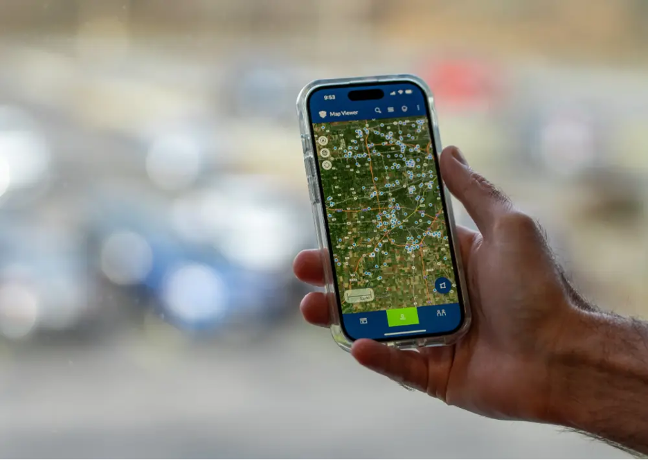 Man holding phone with utility data points being displayed