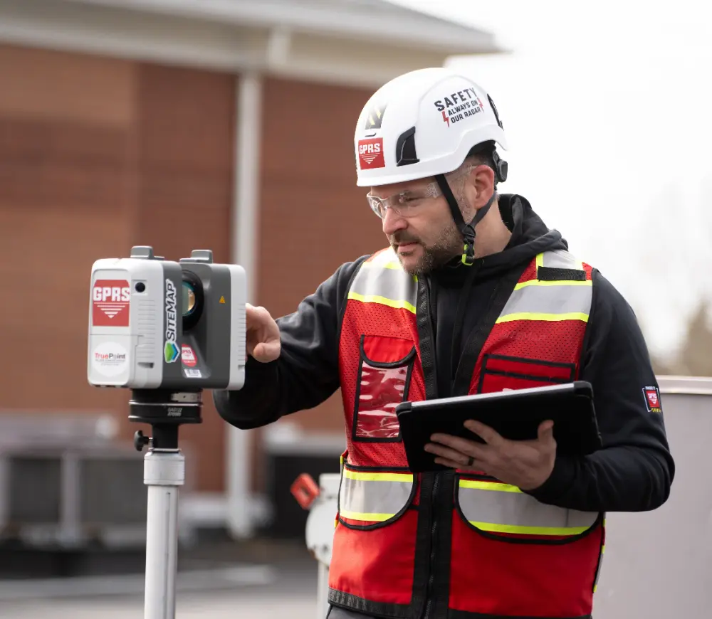 A GPRS Project Manager uses a 3D laser scanner while holding a tablet.