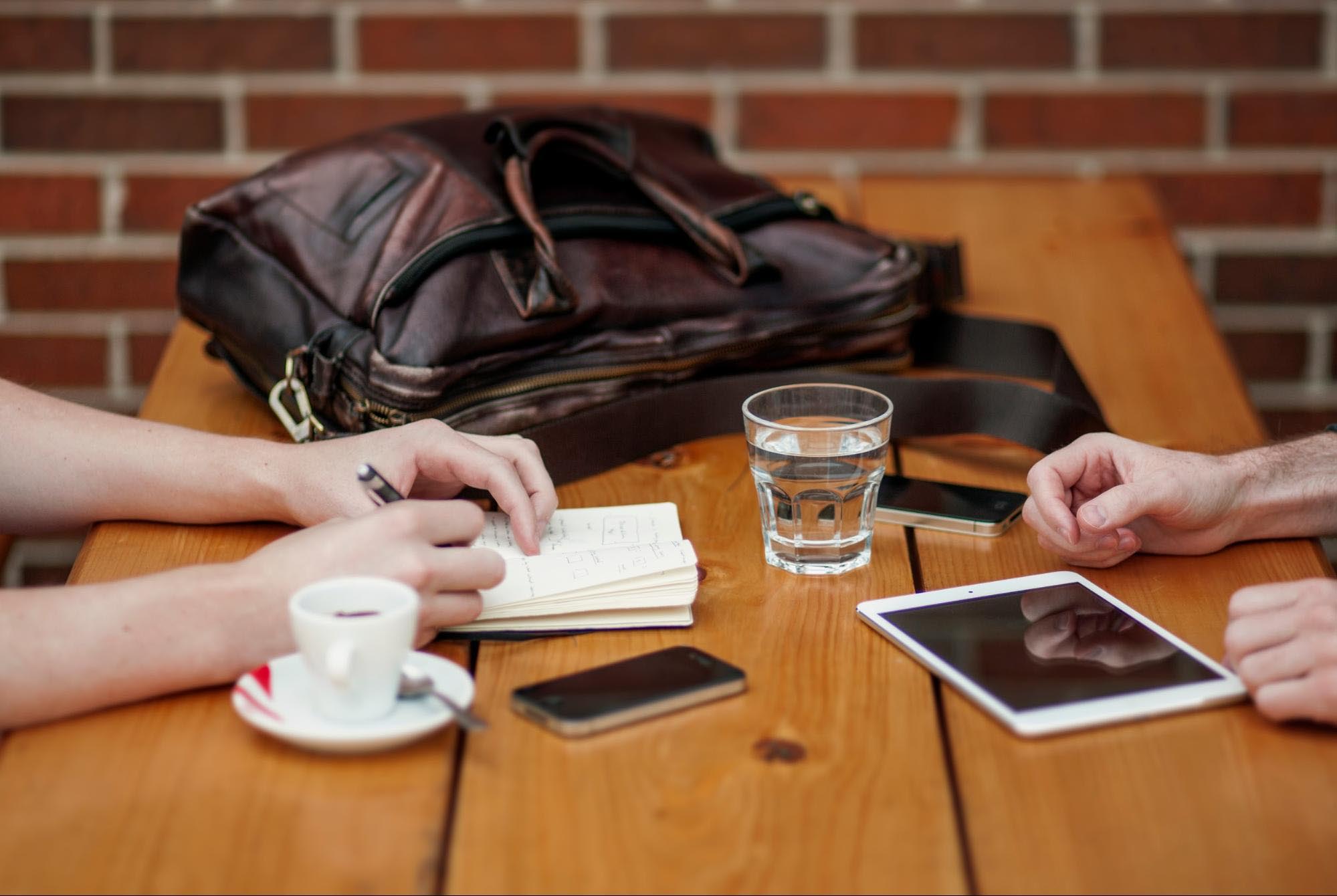 Two people at a table, one taking notes