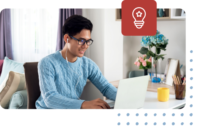 Man smiling while working on laptop at a desk