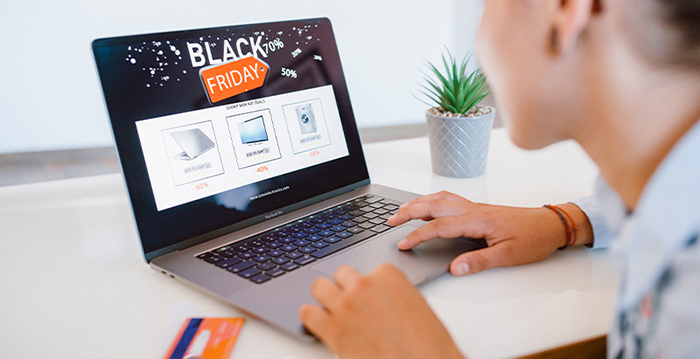 A consumer sitting at a laptop searching for Black Friday deals.