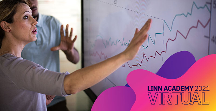 An image of a man and woman analyzing a line graph that shows an upward trend.