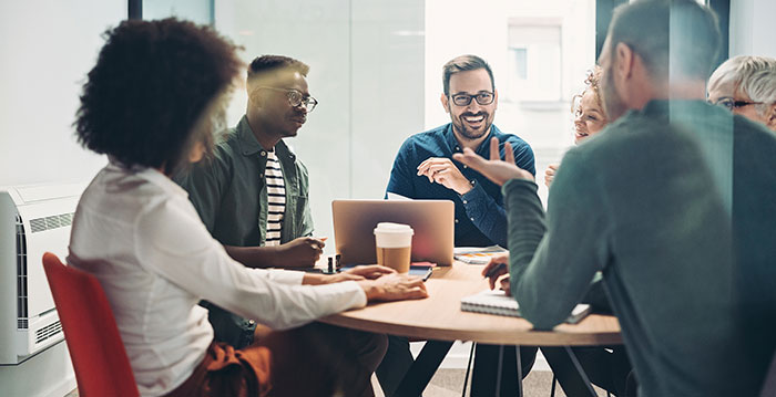 People sitting around a table having a meeting about ecommerce software