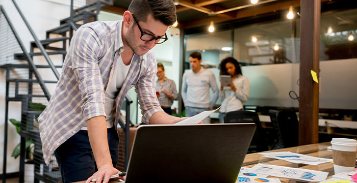 A man looking at inventory forecasting reports as part of ecommerce risk management