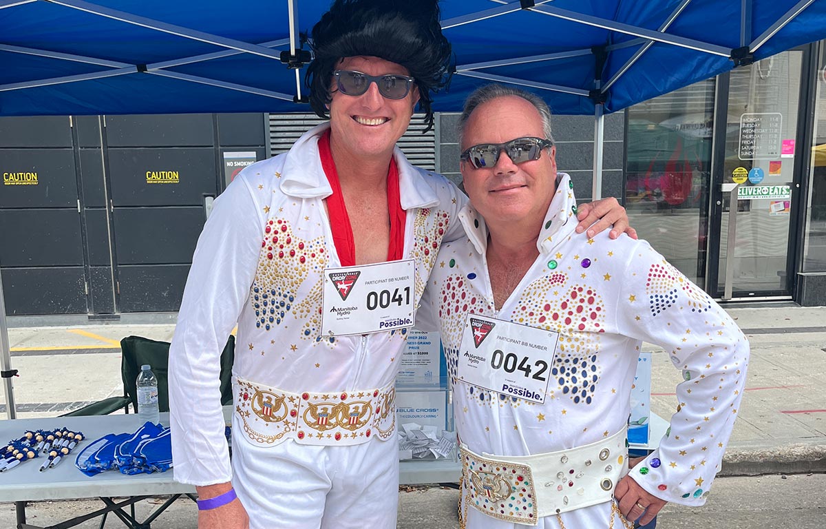 President and CEO Benjamin Graham and Director of Sales David Tompkins are smiling and wearing Elvis costumes.