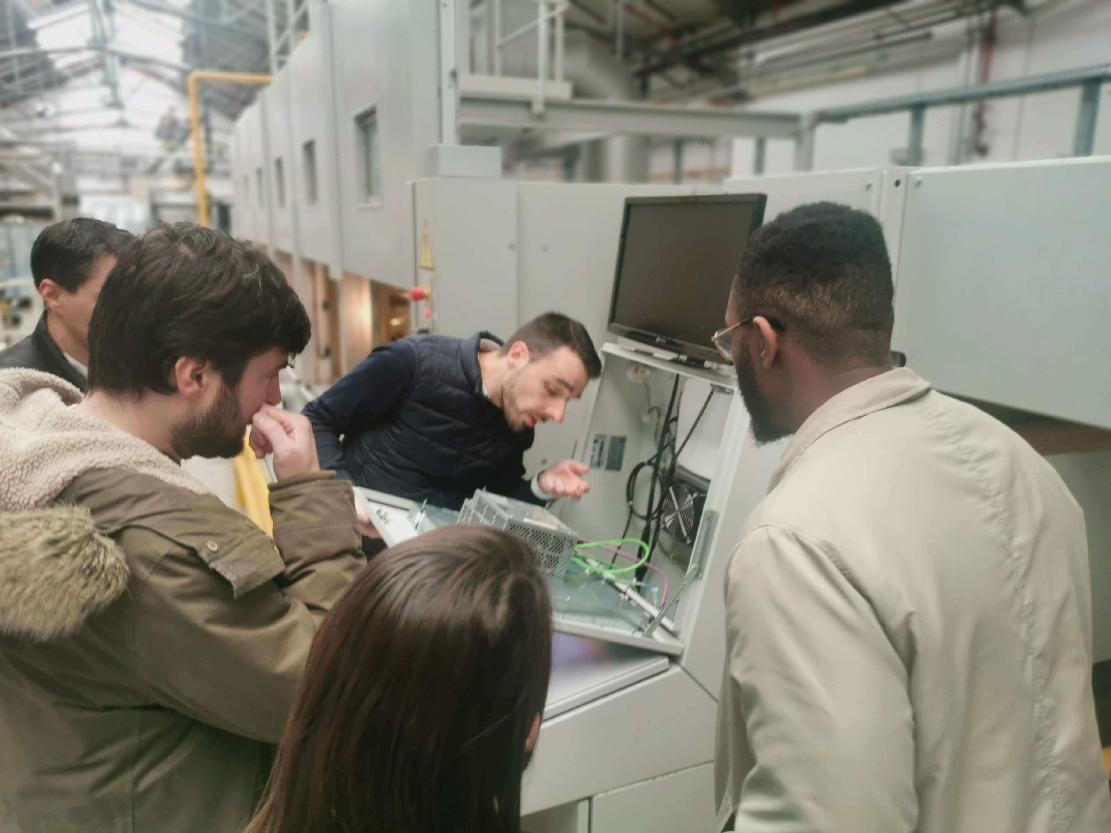 Industrial team leaning together on the interior of a machine