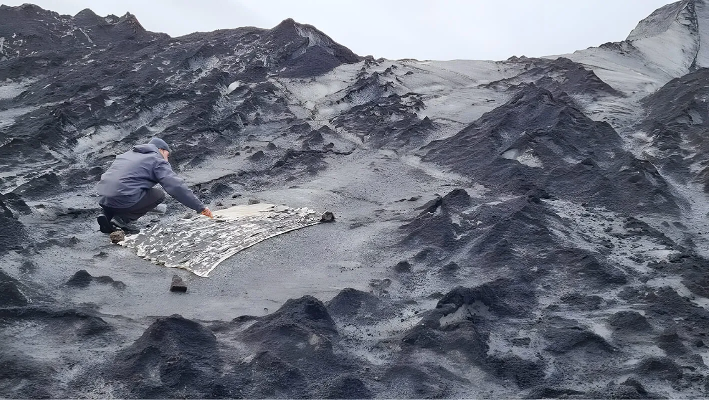 eco artist works on his glacier crack frottage on glacier.