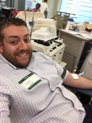 alex smiling while donating blood