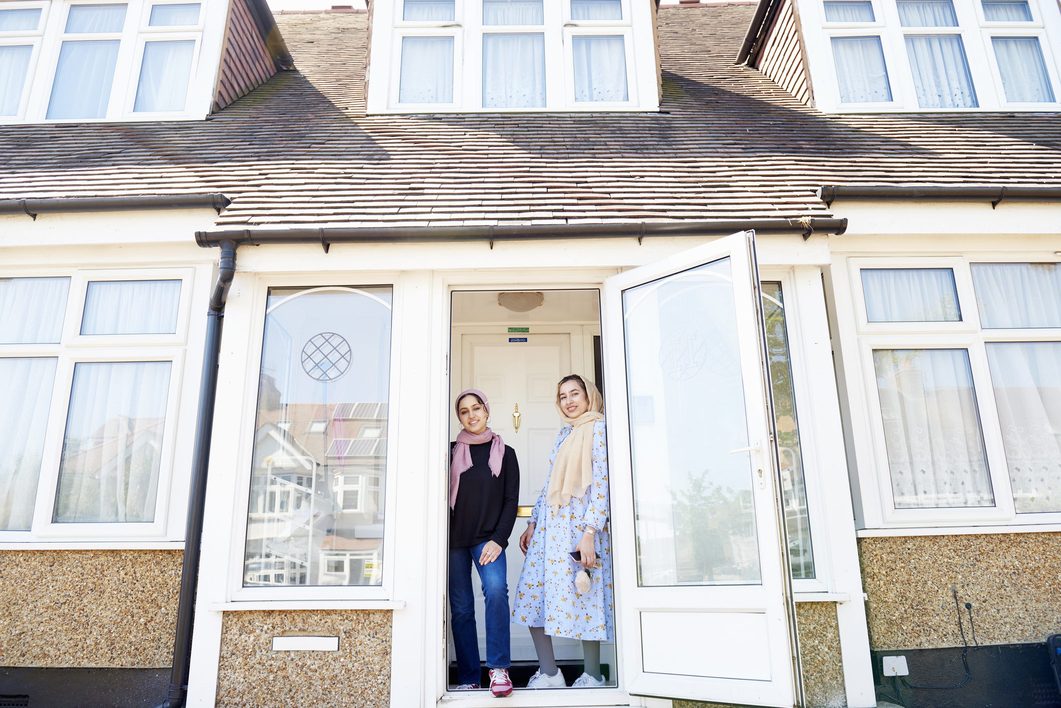 Muslim women in front of a house