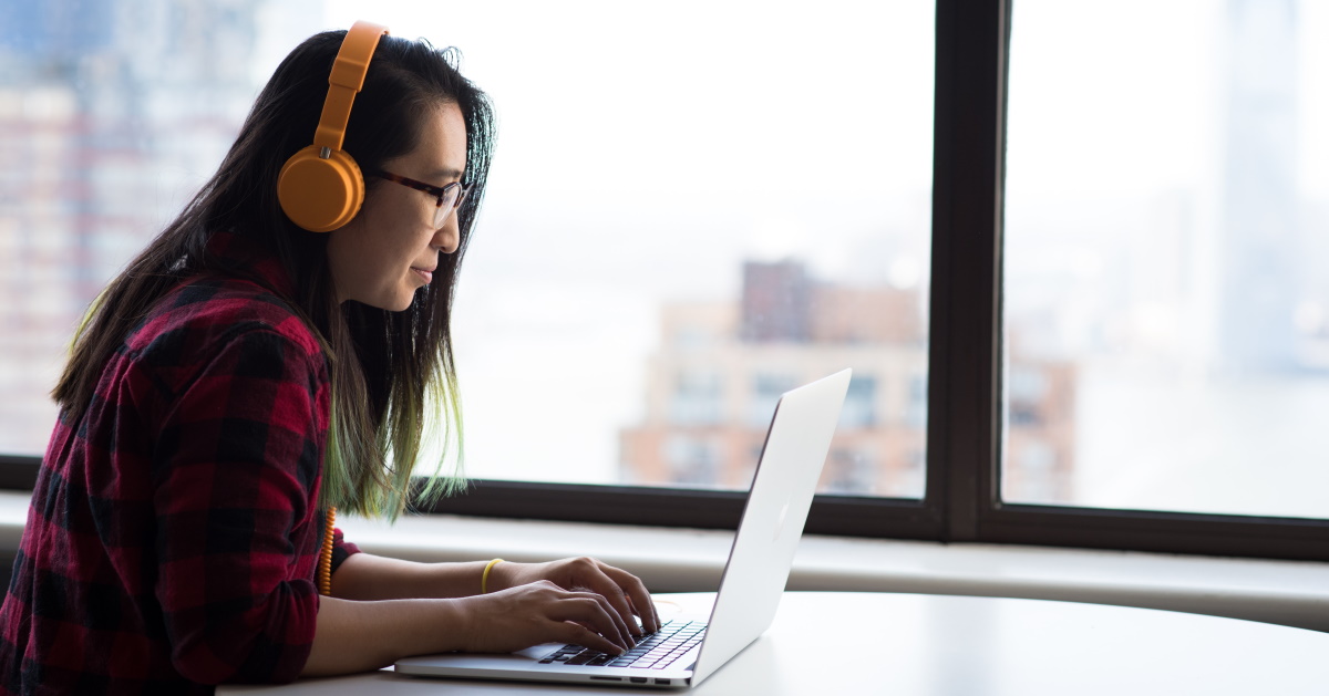 Woman on laptop with headphones