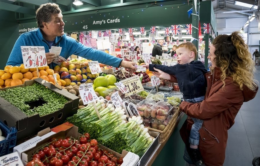 Woman and child at a fruit and veg stall