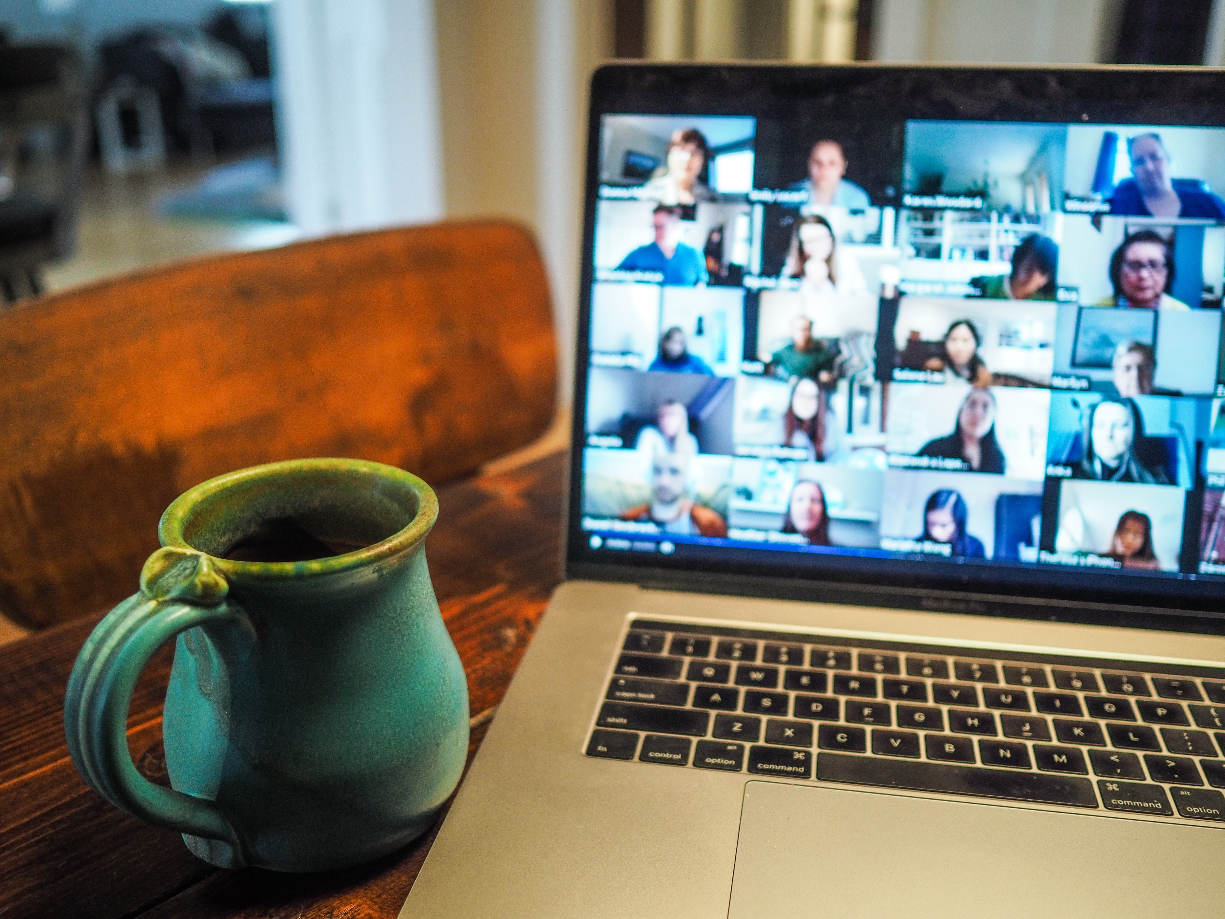 Online call with many faces shown on a laptop